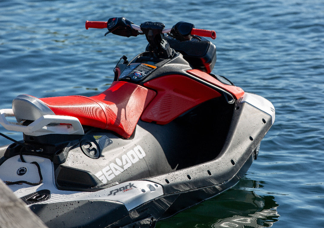 A red and white Sea Doo watercraft labeled 'Spark Trixx' on water.
