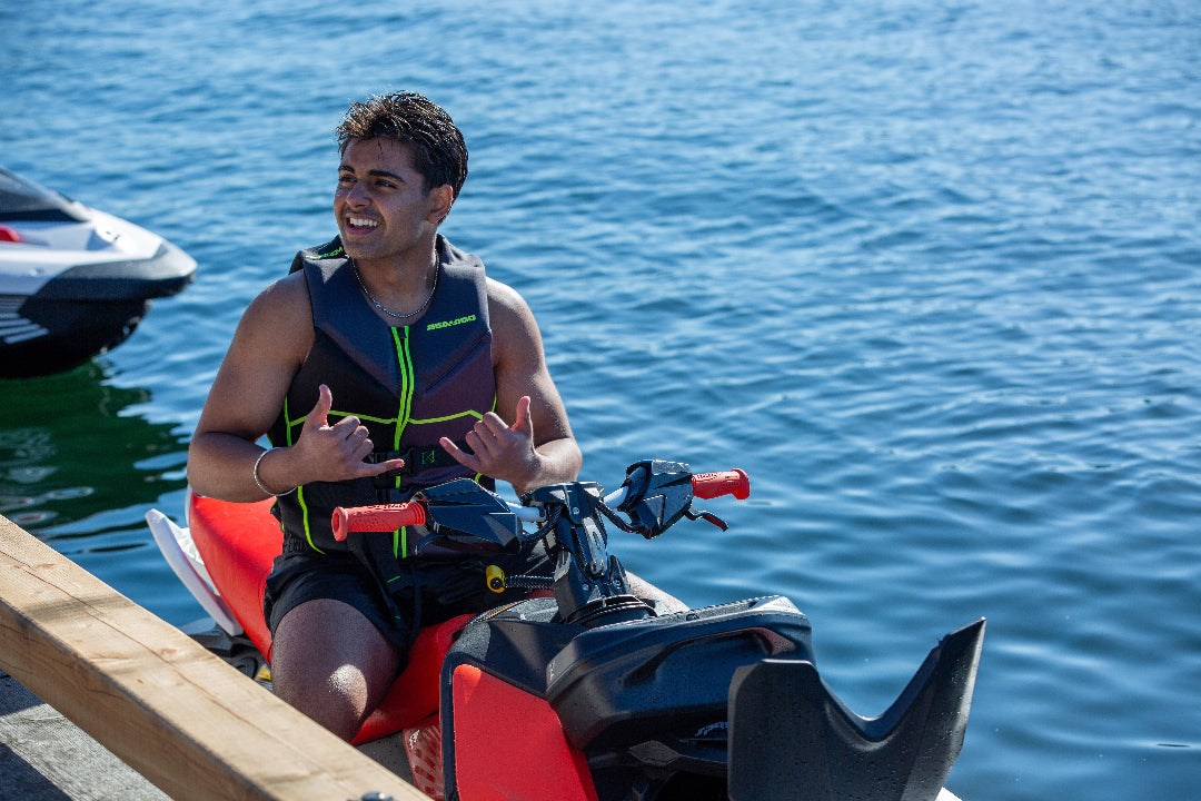 Man posing on jet ski on a lake by a dock