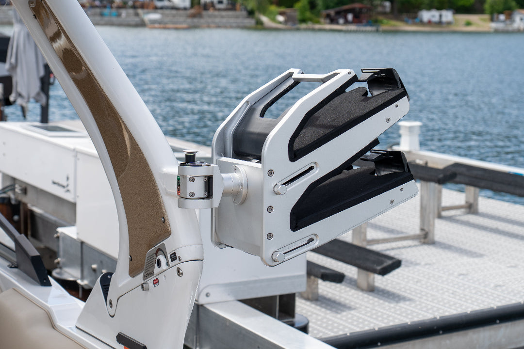 Close-up of a boat's fishing rod holder on a dock with water in the background