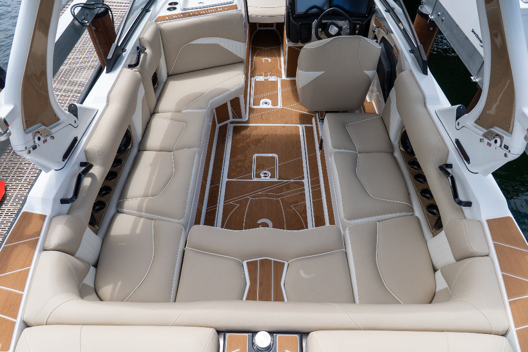 Interior of a luxury boat with beige leather seats and wooden floor.