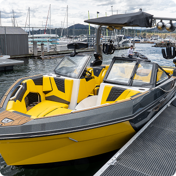 Yellow and black speedboat on a dock with a marina background