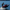 Person riding a Sea-Doo watercraft on a lake with a scenic background