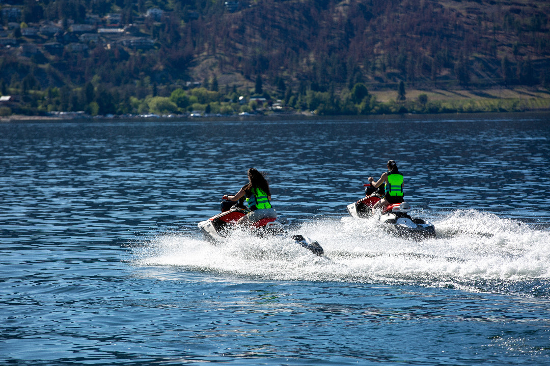 Girls riding jet skis away into the distance on Lake Okanagan