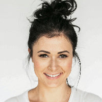 Woman with a stylish hairdo against a plain background